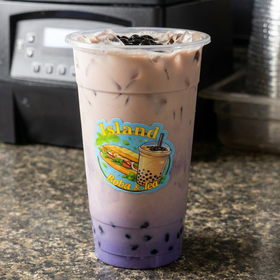 Iced purple boba tea with tapioca pearls in an Island Boba & Tea cup on a countertop.